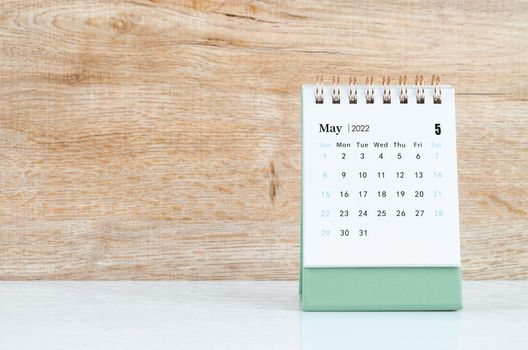 The May 2022 desk calendar on white table.