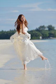 asian  bride with a veil on the beach in the sky and blue sea. honeymoon on the fantastic island at summer