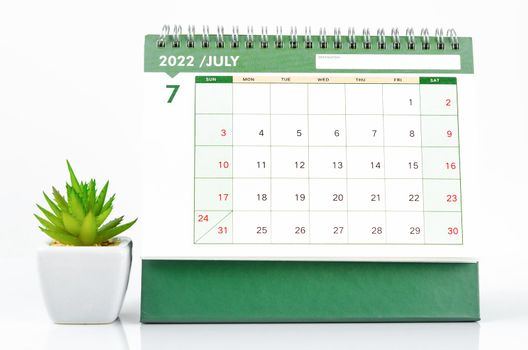 The July 2022 desk calendar with plant pot on white background.