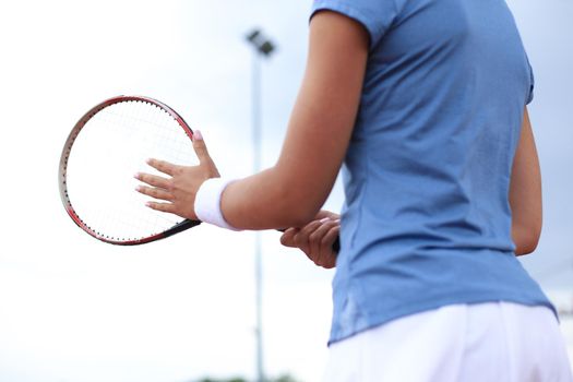 Sportswoman with racquet at the tennis court. Healthy lifestyle