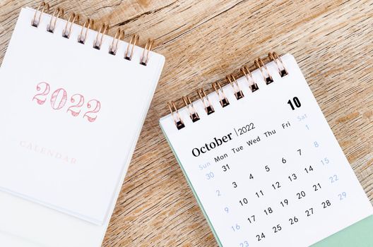 The October 2022 desk calendar on wooden table.