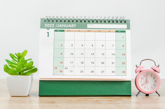 The January 2022 desk calendar on wooden table.