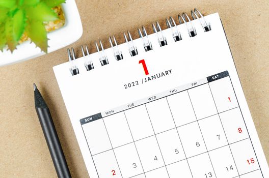 The January 2022 desk calendar on brown background.