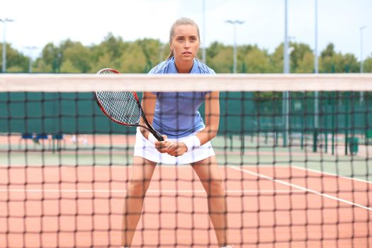 Pretty sportswoman with racquet at the tennis court. Healthy lifestyle