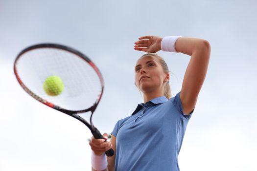 Pretty sportswoman with racquet at the tennis court. Healthy lifestyle