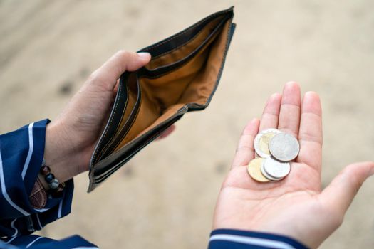 Woman holds an empty purse and coins in hand meaning money financial problem or bankrupt jobless, broke after credit card payday jobless, debt concept.