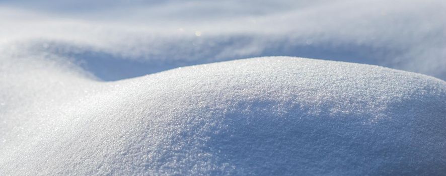 Drifts of fresh snow sparkling in the sun on a frosty day. Nature winter background.