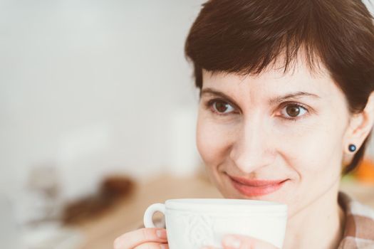 Anosmia, restore sense of smell, lossing due to COVID-19. Close up happy smiling woman sniffing coffee from cup, copy space