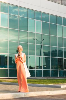 Portrait of Muslim woman wearing Hijab outdoor using mobile phone.