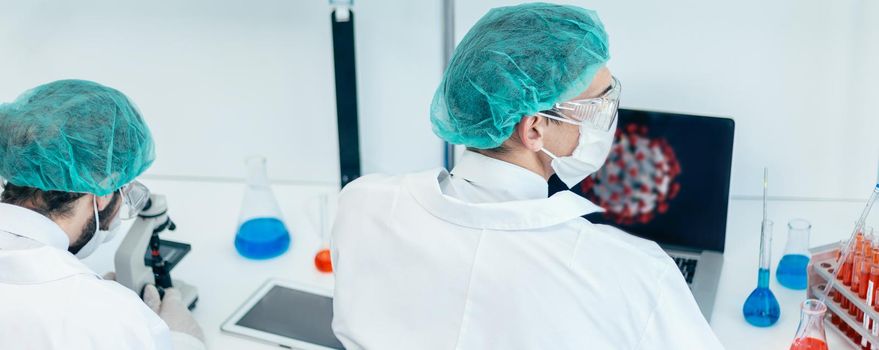 rear view. scientist sitting at a Desk in the laboratory. the concept of health care.