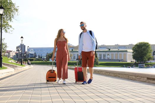 Summer holidays, tourism concept - smiling couple with luggage.