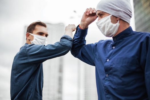 close up. two young men greeting each other with their elbows. concept of health protection