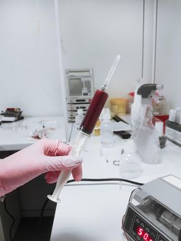 close up. syringe with blood for transfusion in the hands of a veterinarian