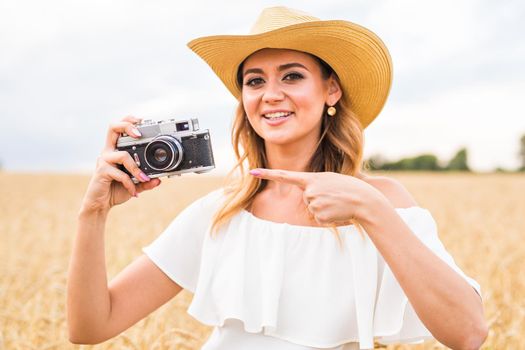 female photographer in the field with a camera taking pictures.