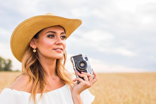 female photographer in the field with a camera taking pictures.