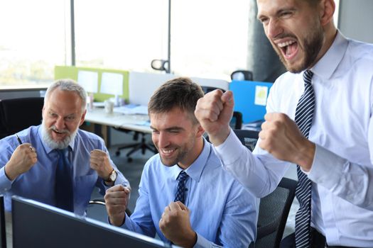 Group of modern business men in formalwear smiling and gesturing while working in the office