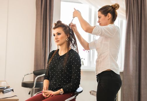 beauty and people concept - happy young woman with hairdresser at hair salon.