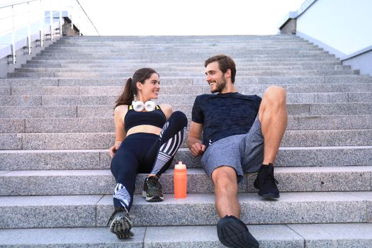 Young couple in sportswear sitting on the stairs after exercising outdoors