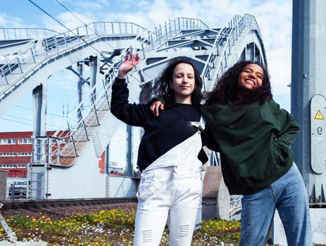 young cute teenage girls together in industrial zone happy smiling having fun, big city lifestyle fashion people close up