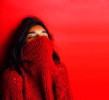 young pretty indian girl in red sweater posing emotional, fashion hipster teenage, lifestyle people concept closeup