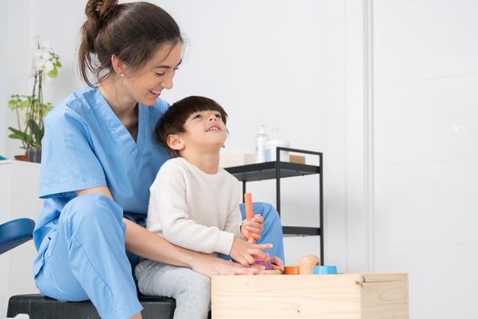 Physical therapist playing with a boy who has cerebral palsy. High quality photo.