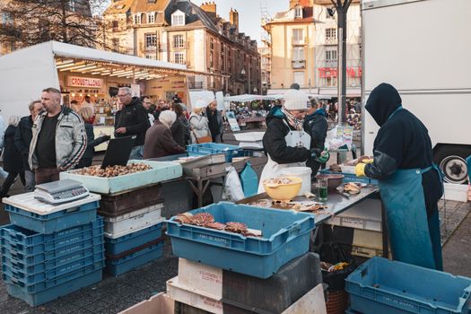 DIEPPE, FRANCE - NOVEMBER 17, 2018: Vendors sell freshly caught fresh scallops at the Fair of Herring and scallop shell in a port of Dieppe