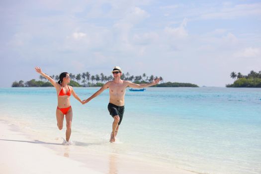 happy young romantic couple in love have fun running and relaxing on beautiful beach