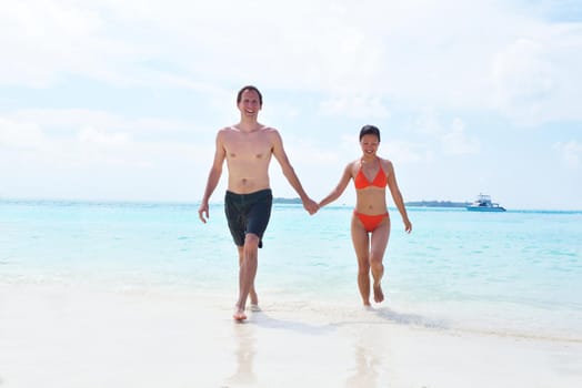 happy young romantic couple in love have fun running and relaxing on beautiful beach