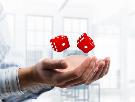 Close of businessman hands with dice as game concept. Mixed media