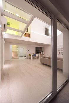 outside view trough window on interior of a luxury stylish modern open space design two level apartment with white walls