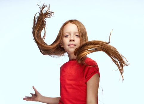 girl with red hair posing red t-shirt childhood. High quality photo