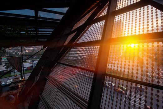 sunset or sunrise above the city through a glass roof in a modern building