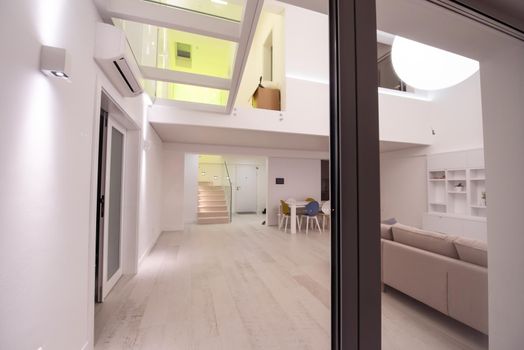 outside view trough window on interior of a luxury stylish modern open space design two level apartment with white walls