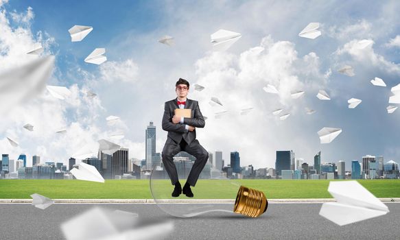 young businessman with a book. flying around paper plane in chaos