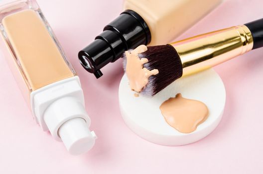 Liquid foundation makeup with brush and sponge on beautiful background;