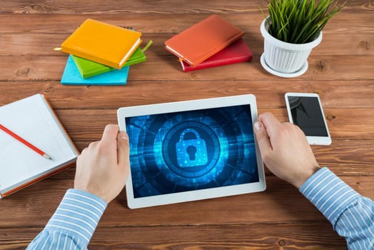 close-up, male hands with tablet. Businessman working at the table in office. computer security concept