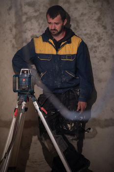 professional worker using laser level in a building under construction. Laser equipment at a construction site