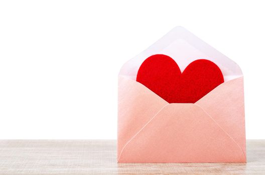 Fabric red heart shape in pink envelupe on wooden background, Valentine concept.