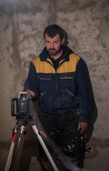 professional worker using laser level in a building under construction. Laser equipment at a construction site