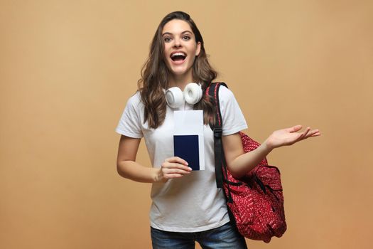 Smiling student girl going on a travel isolated on beige background