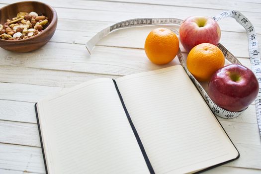 notepad on table measuring tape fruit breakfast nutritional fitness. High quality photo