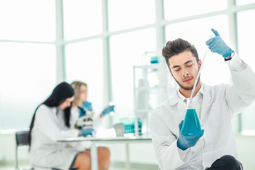 close up. the young scientist makes the analysis of the liquid in the flask . photo with copy space