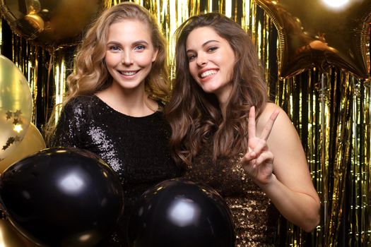 Beautiful girls celebrating New Year. Gorgeous smiling young women enjoying party celebration, having fun together