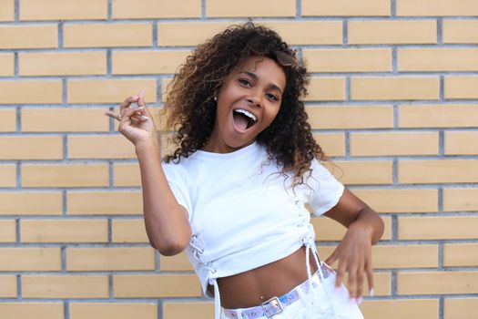 Beautiful smiling brunette model dressed in summer hipster clothes. Funny and positive woman having fun