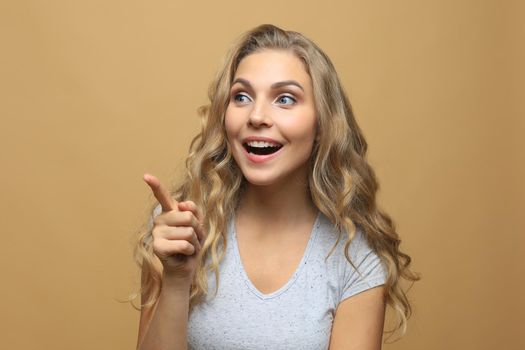 Happy young fashion woman posing for the camera while pointing at you