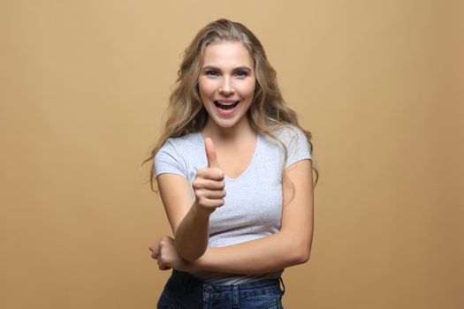 Young happy cheerful woman showing thumb up