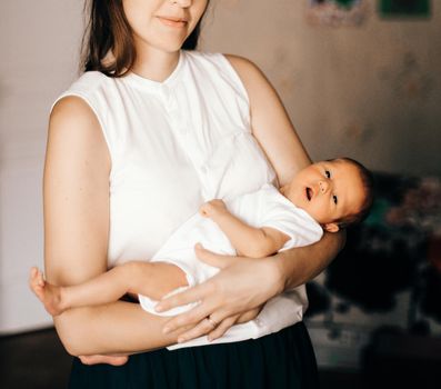 young mother with a newborn baby in the nursery