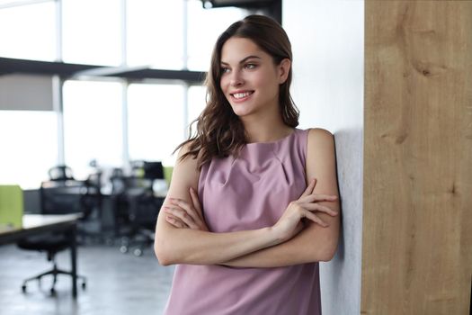 Attractive business woman smiling while standing in the office