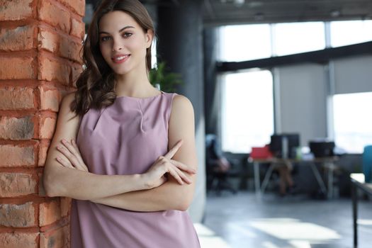 Attractive business woman smiling while standing in the office