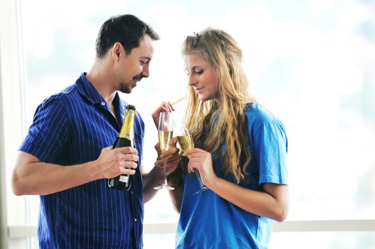 happy couple at big bright comfort apartment celebrate with glasses of champagne